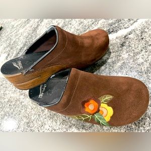 Dansko brown suede clogs with embroidered flowers.